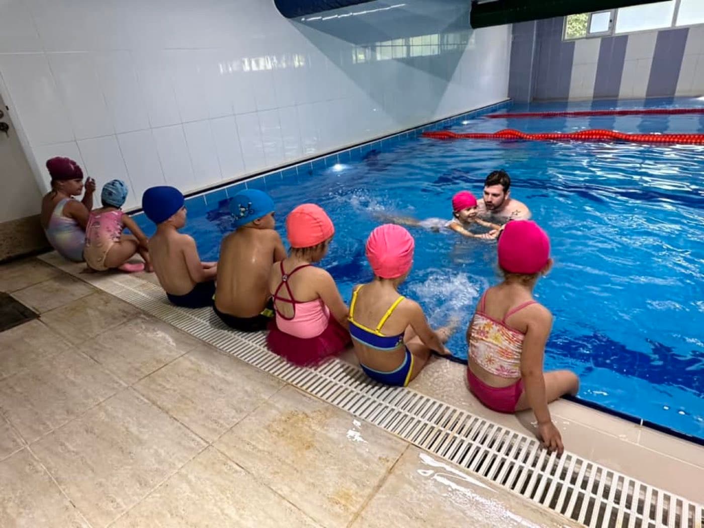 Kendi havuzunda yüzme öğrenen çocuklar